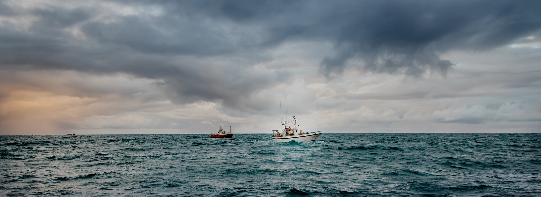 A mackerel fishing boat out at sea under a dramatic sky